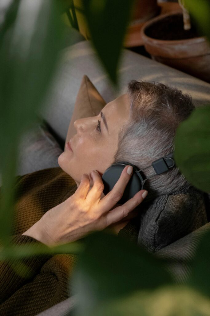 Person wearing a brain-sensing neurofeedback headband while meditating in a calm indoor setting.